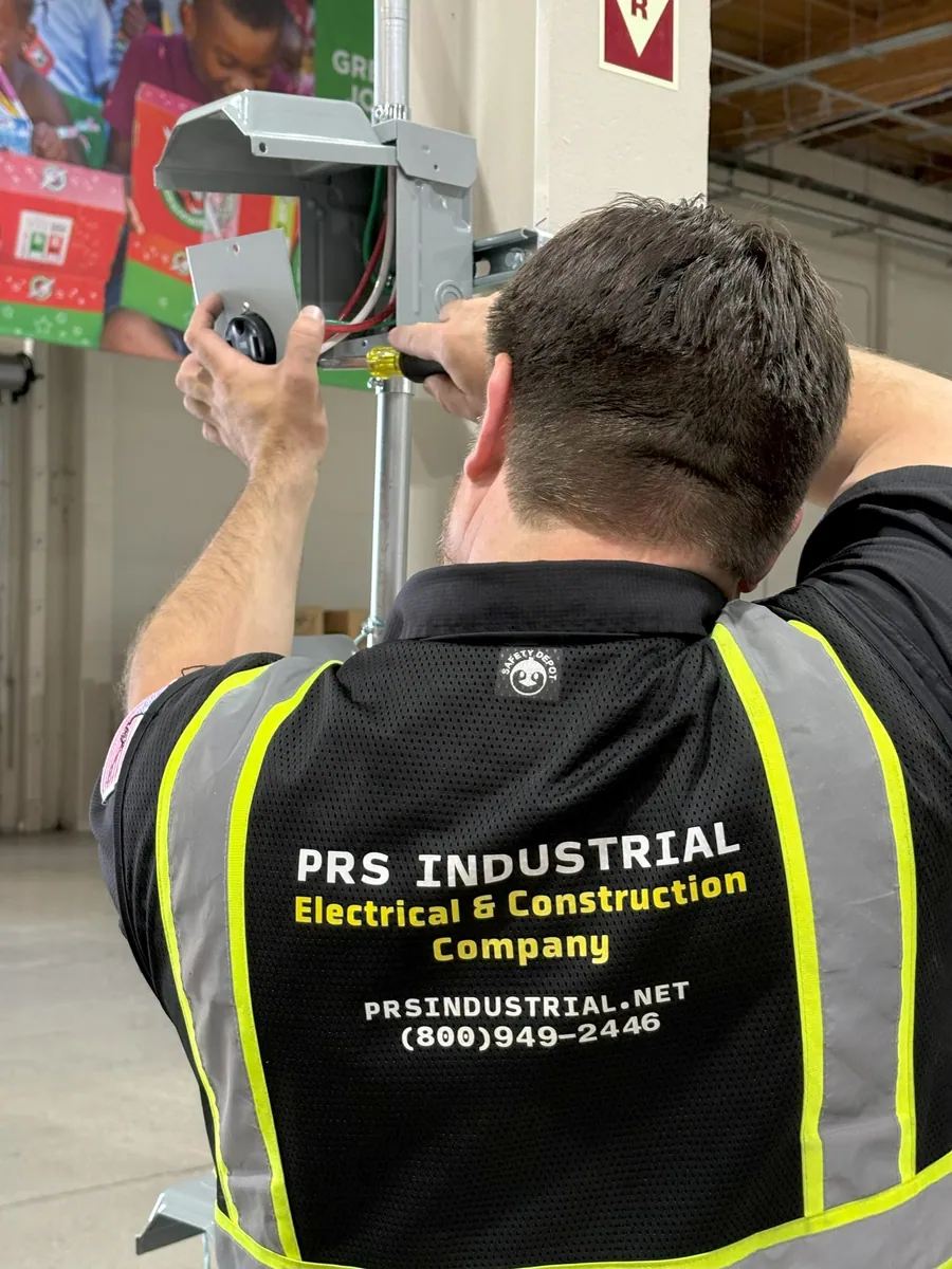 Technician working on a warehouse electrical outlet