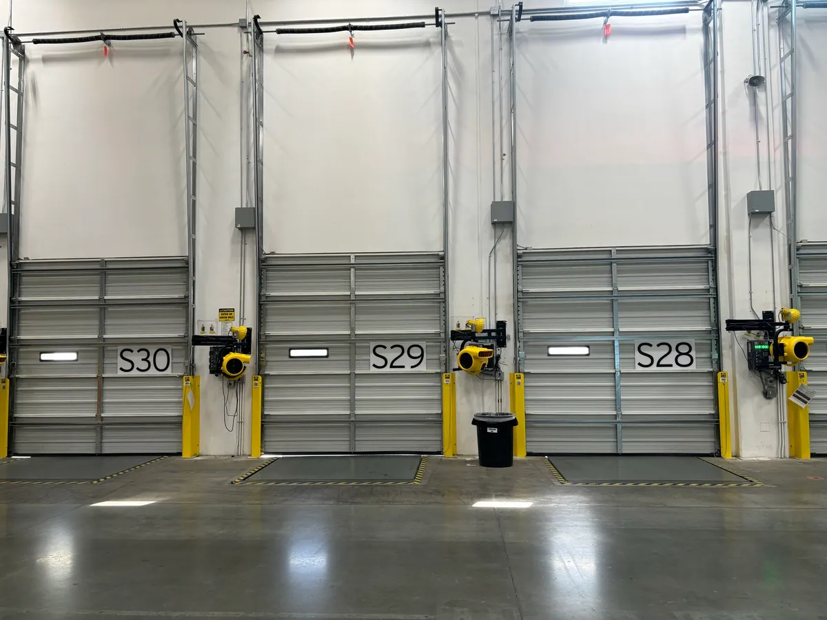 Warehouse loading dock doors with dock levelers
